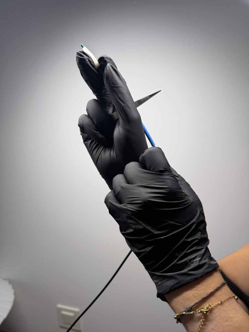 Électrolyse : aiguille fine du stylet Apilus tenue en main gantée